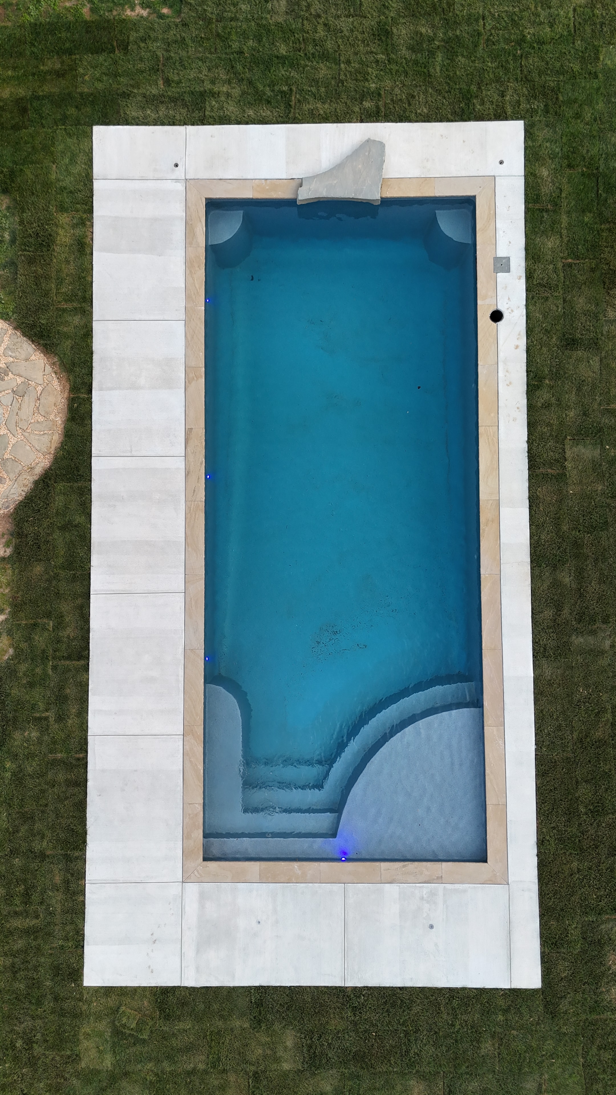 LandPro aerial pool with white concrete surround and lounge chairs