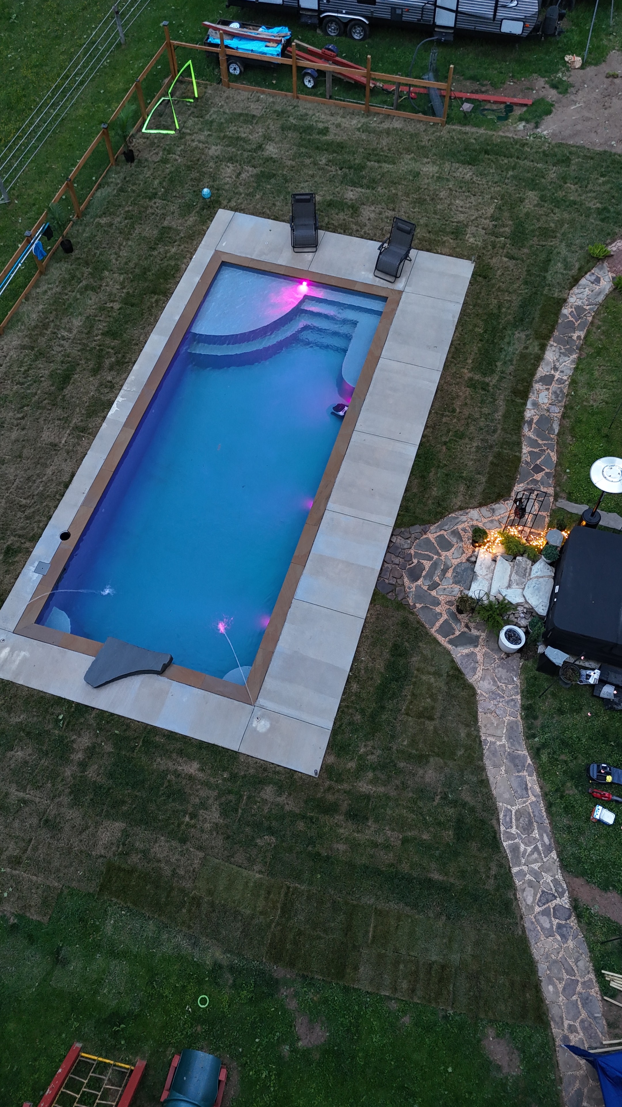 LandPro aerial dusk shot of pool glowing pink with stone pathway