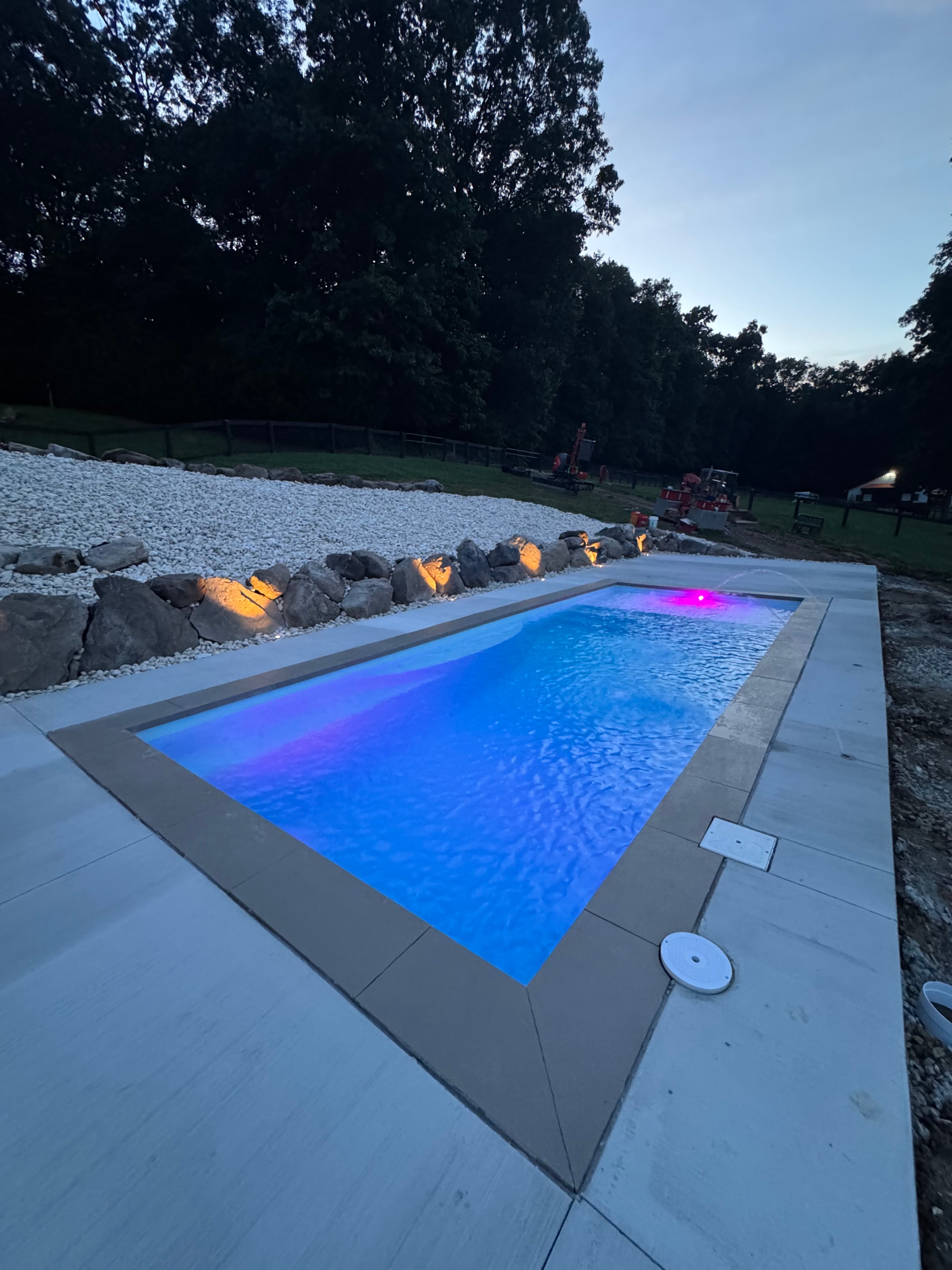 LandPro pool glowing blue with LED lighting at dusk