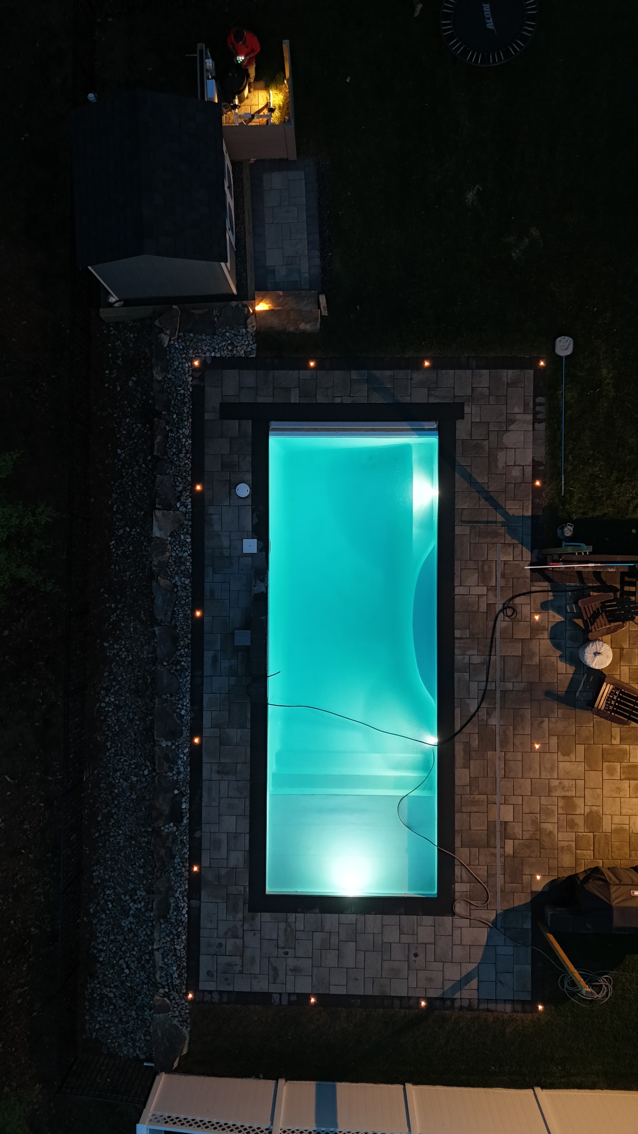 LandPro pool at sunset with shed and stone steps