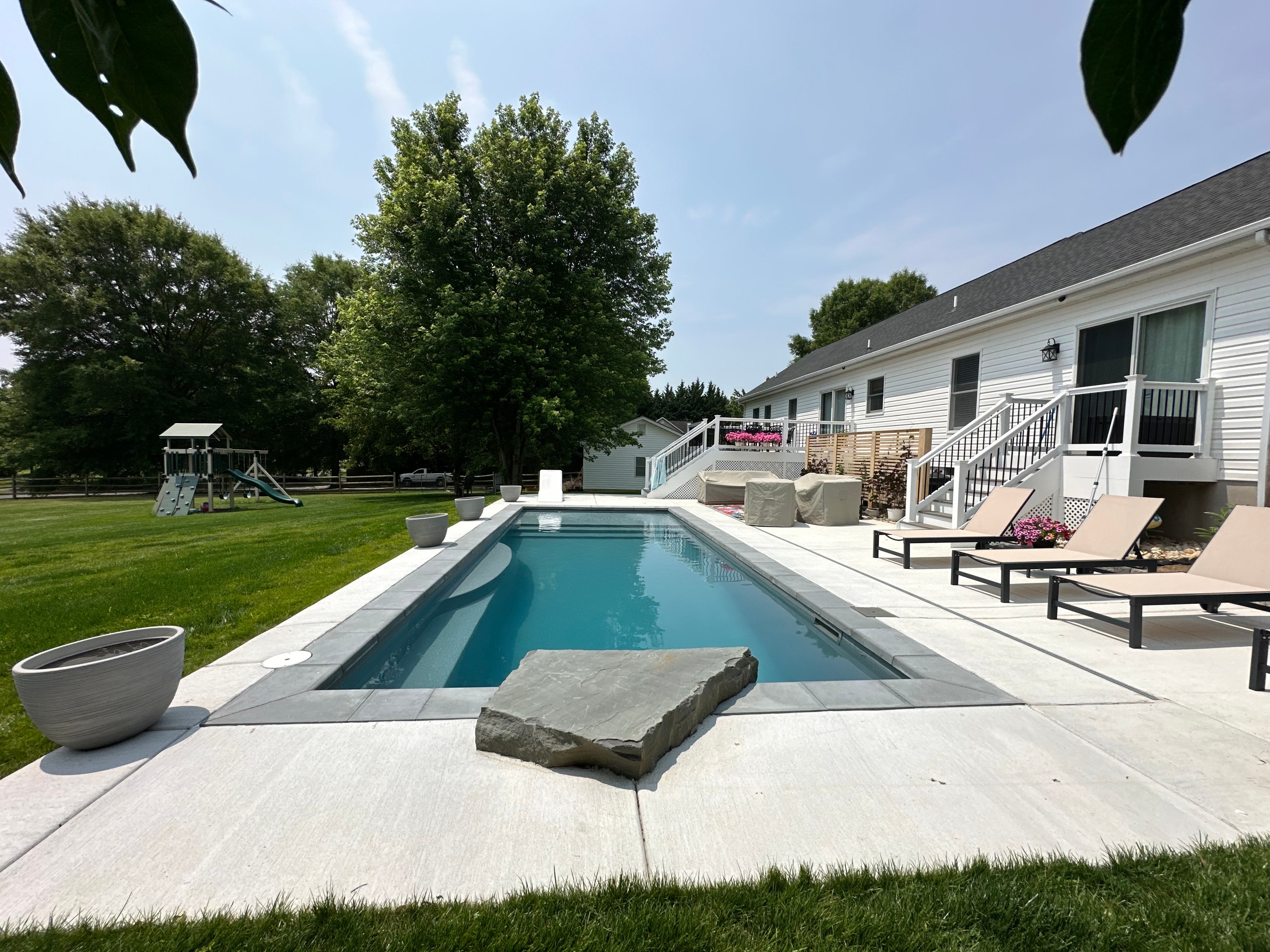 Backyard for the Kids — elevated view of pool with patio and playground beyond