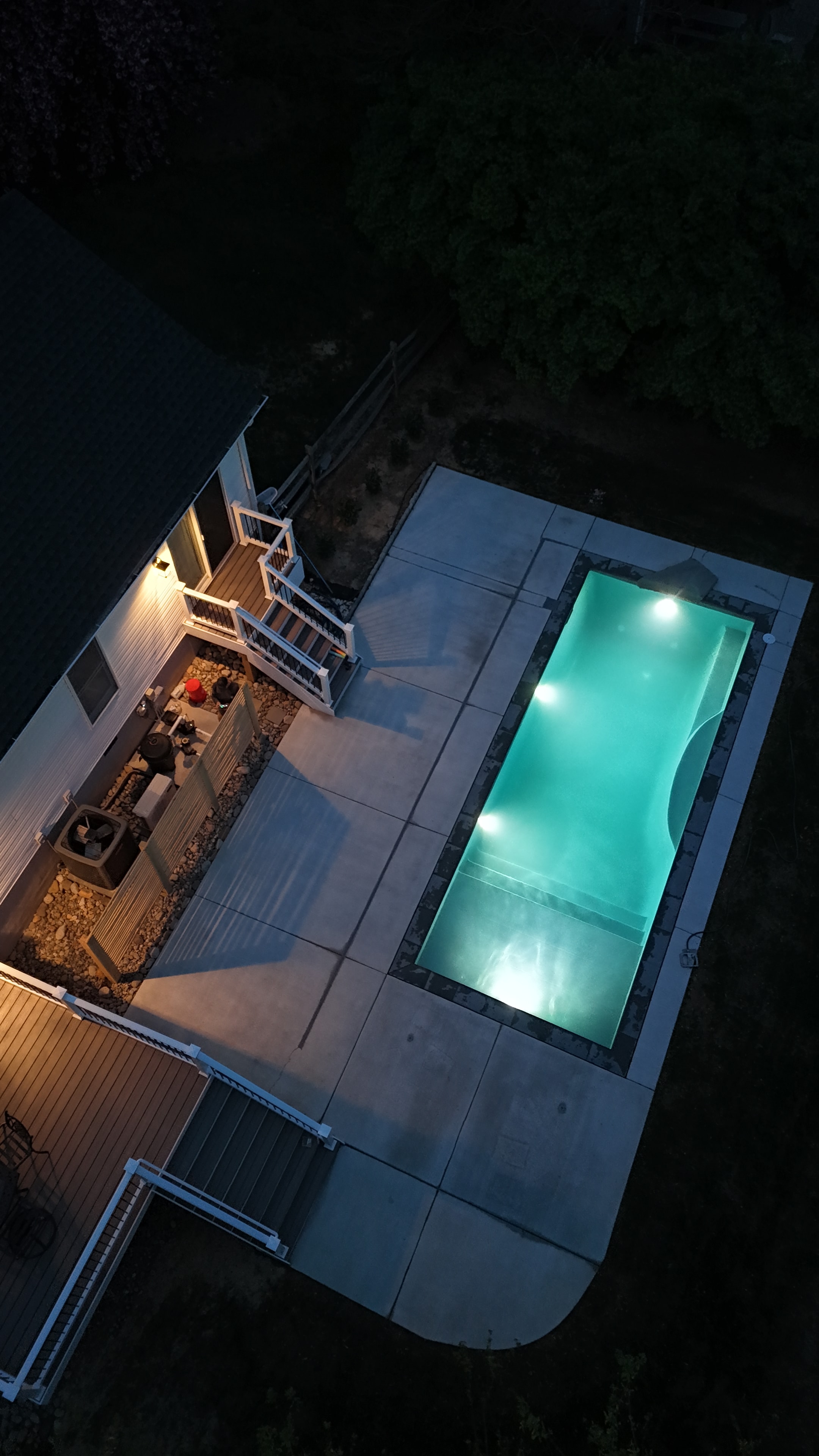 Backyard for the Kids — aerial night shot of pool glowing teal with LED lighting