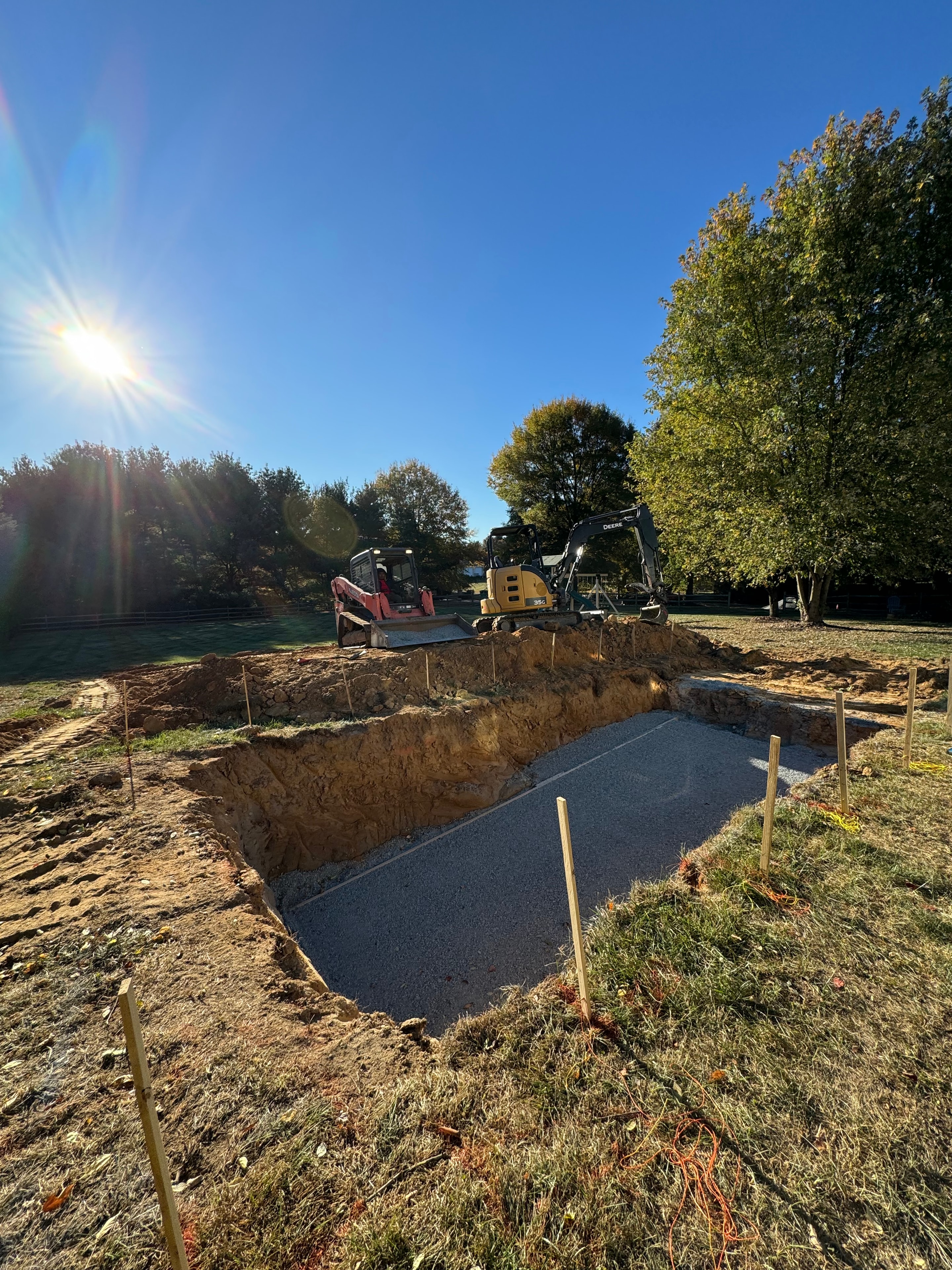 Under construction — excavation in progress with pool shell footprint taking shape