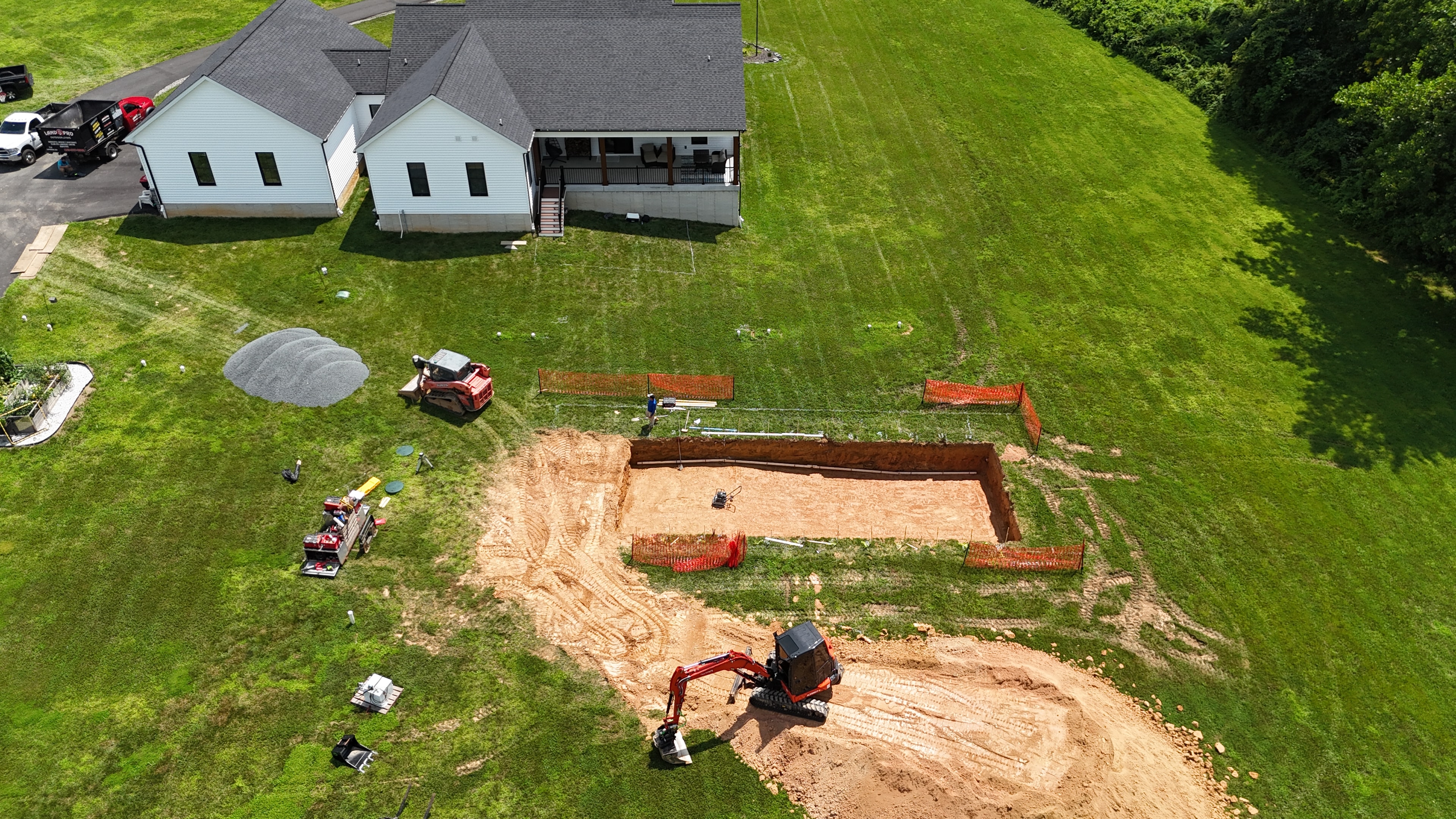 Under construction — aerial view of excavated pool area with equipment on site