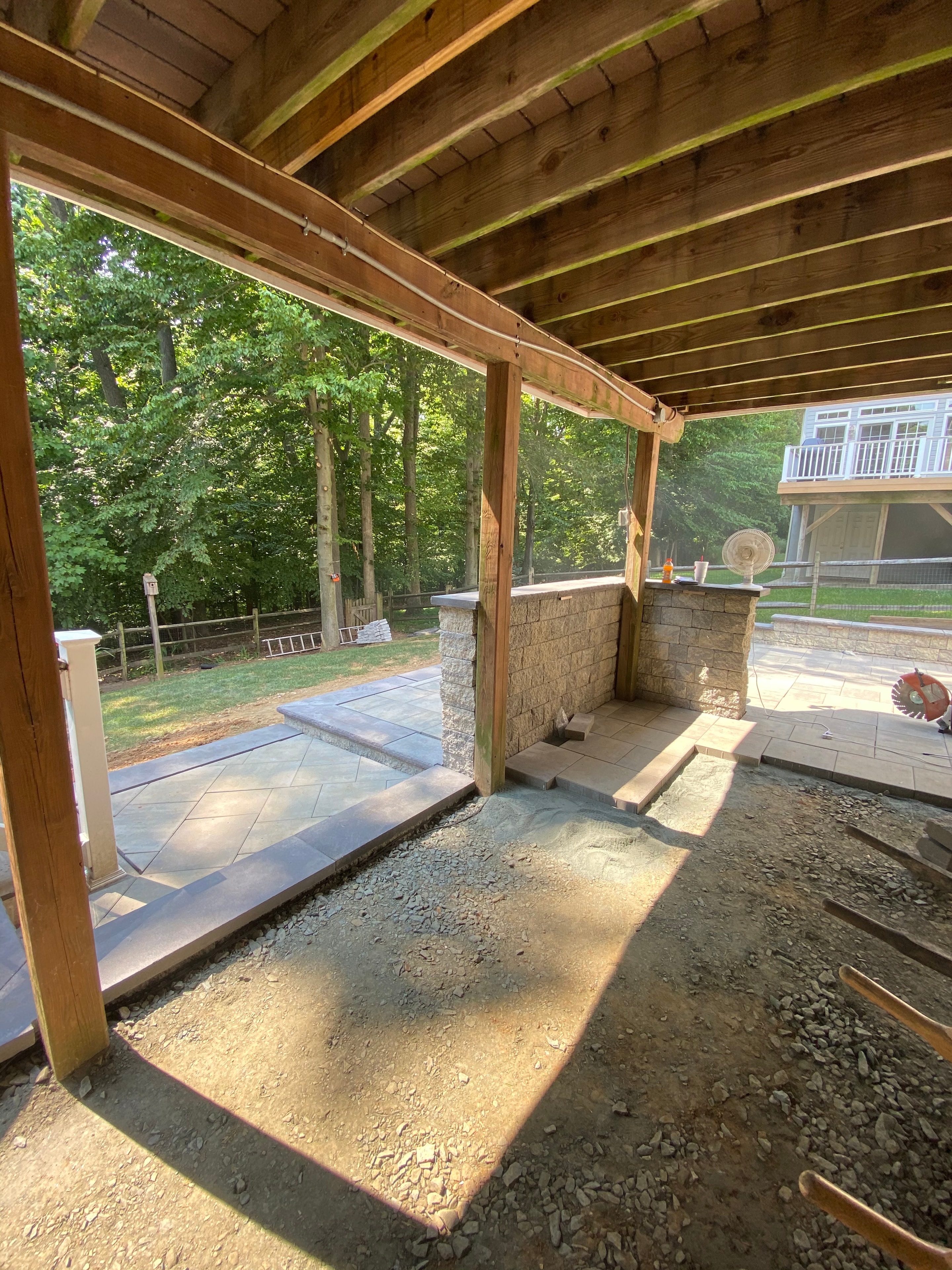 Under construction — view from deck framing showing paver patio and putting green base being installed