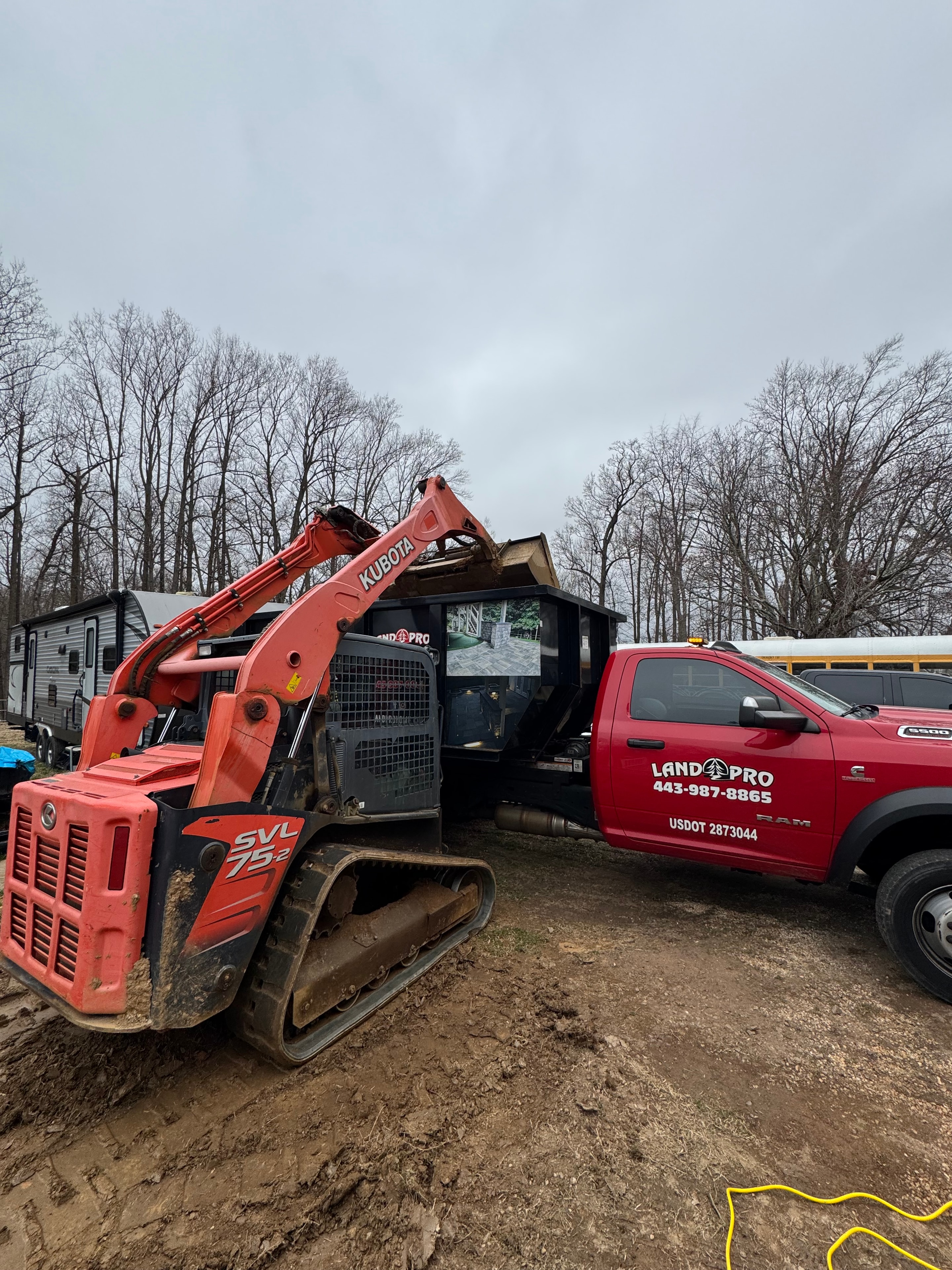 Under construction — LandPro truck and Kubota skid steer staged on site ready for excavation